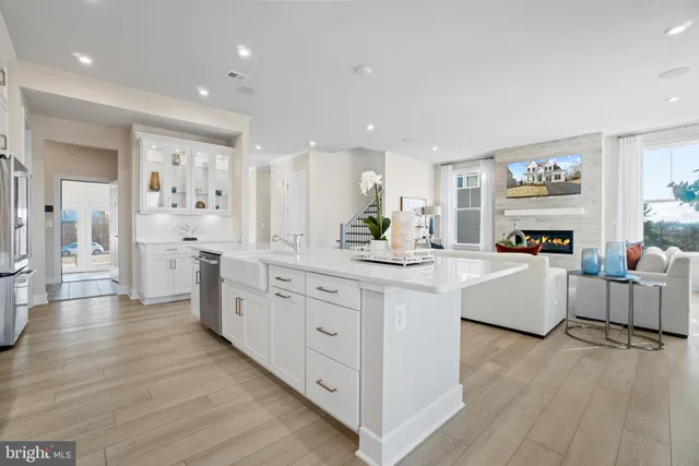a large white kitchen with kitchen island white cabinets and stainless steel appliances