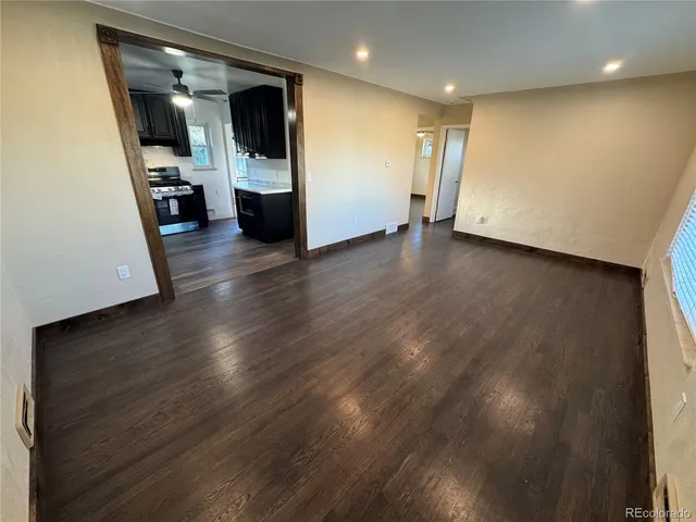 a view of a big room with wooden floor and windows