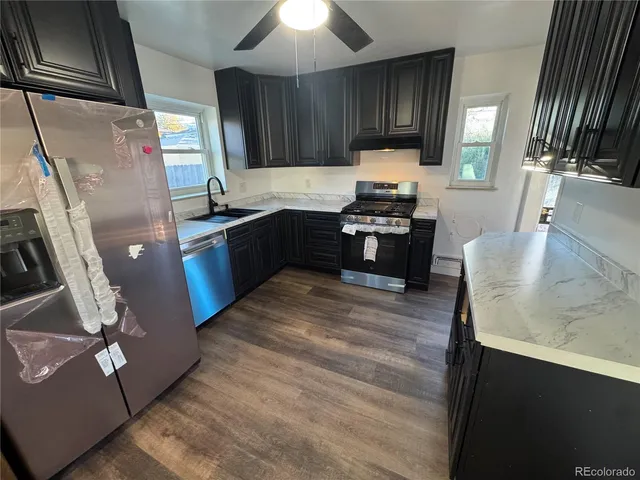 a kitchen with granite countertop a refrigerator stove and sink