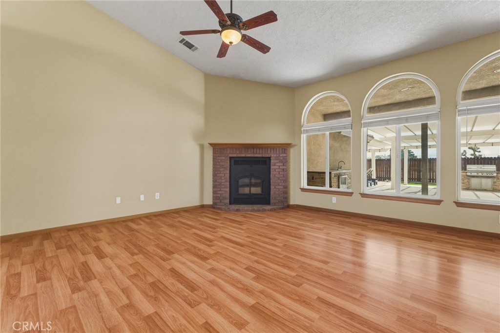 19501 Kinai Road Apple Valley, CA 92307 - Photo 12 of 49 a view of an empty room with wooden floor and a window