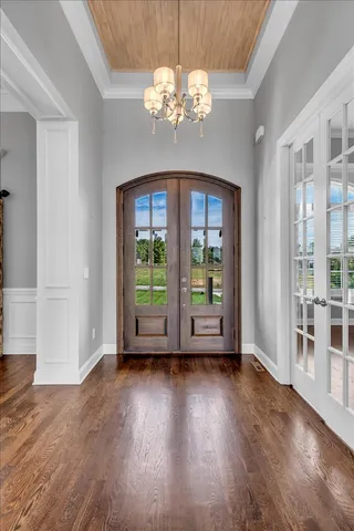 an empty room with wooden floor fireplace and windows