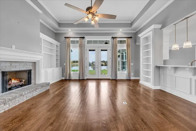 a view of an empty room with window and wooden floor