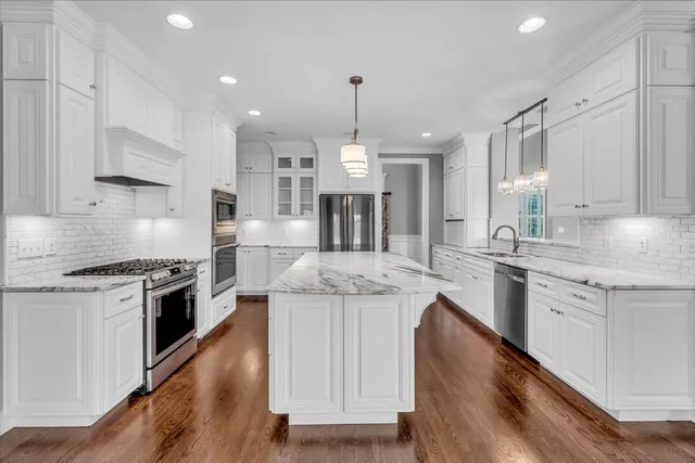 a bathroom with a granite countertop sink a mirror and a bathtub