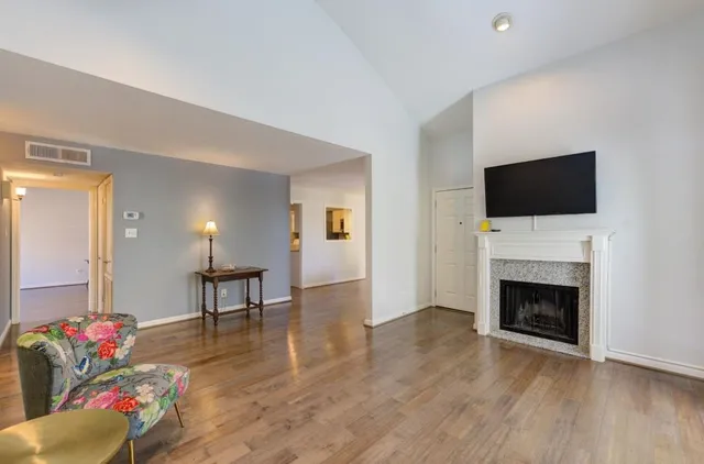 a living room with furniture a fireplace and a flat screen tv