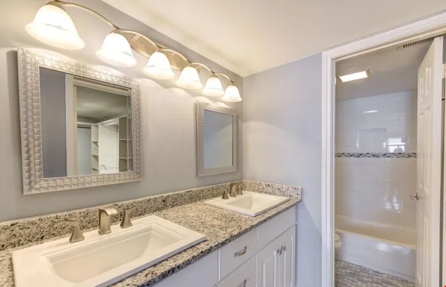 a bathroom with a granite countertop sink and a mirror