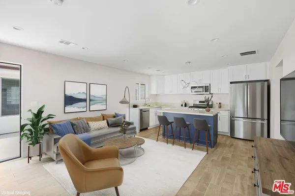a living room with stainless steel appliances kitchen island furniture and a kitchen view