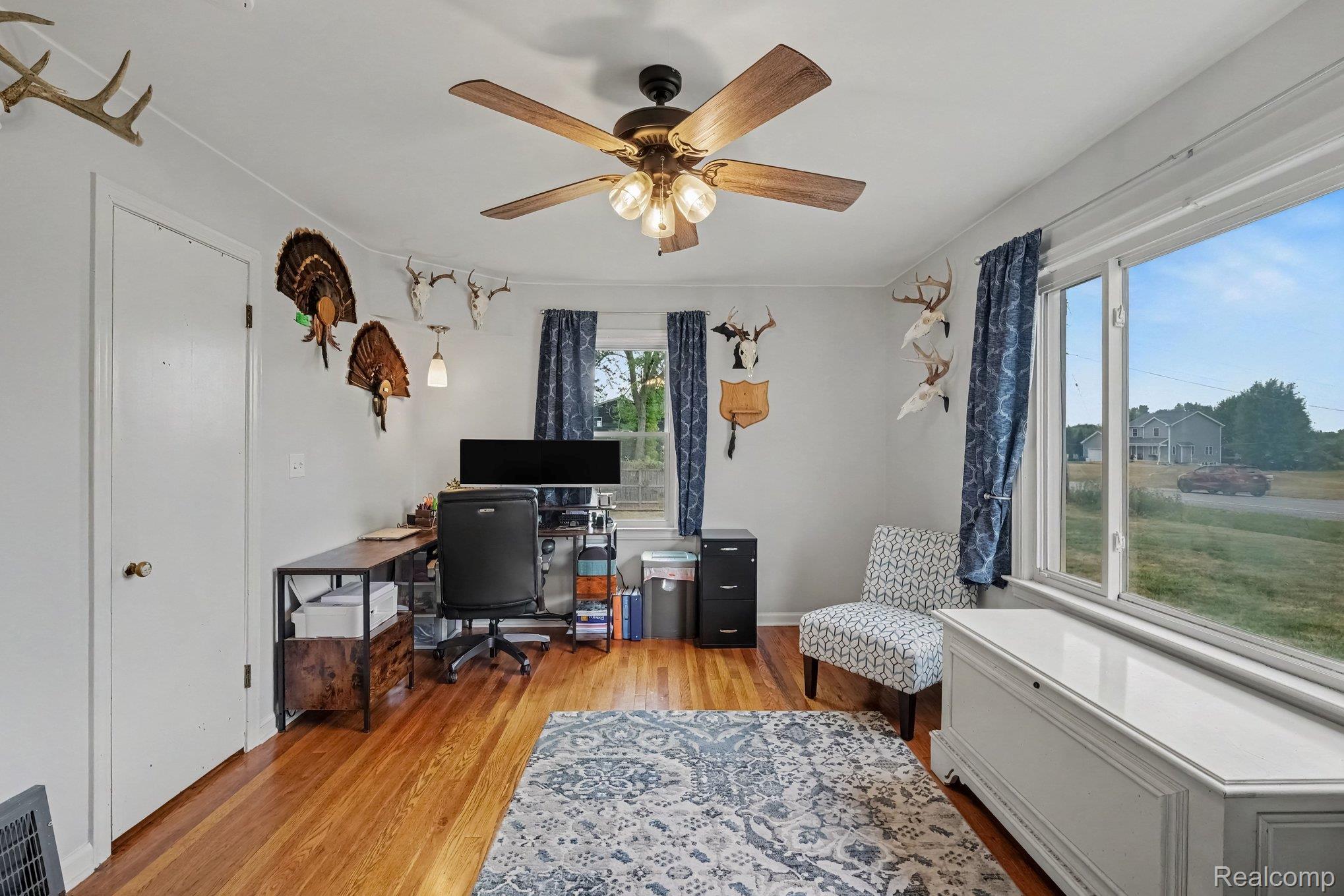 5409 Baldwin Road Swartz Creek, MI 48473 - Photo 12 of 27 Wood-finish flooring, white walls, and a ceiling fan with light fixture