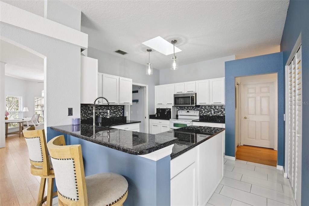 7164 Spikerush Court Lakewood Ranch, FL 34202 - Photo 12 of 36 a large kitchen with kitchen island a large counter top space appliances and cabinets