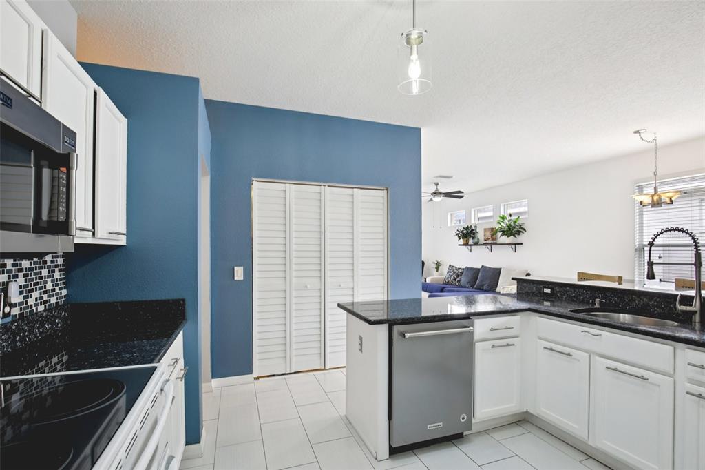 7164 Spikerush Court Lakewood Ranch, FL 34202 - Photo 14 of 36 a kitchen with stainless steel appliances granite countertop a sink and cabinets