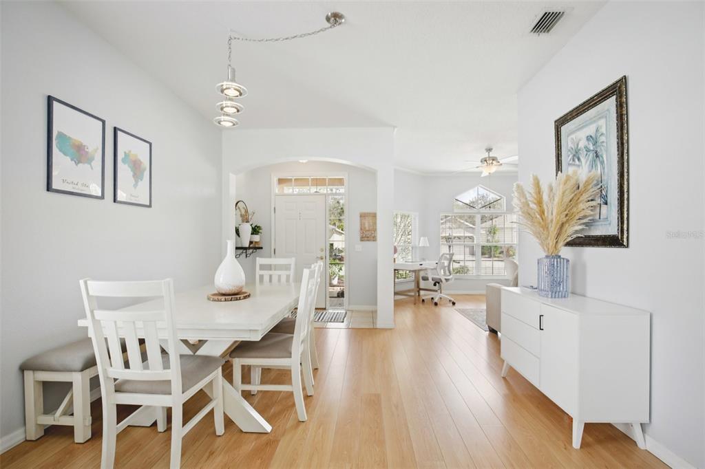 7164 Spikerush Court Lakewood Ranch, FL 34202 - Photo 6 of 36 a view of a dining room with furniture and wooden floor