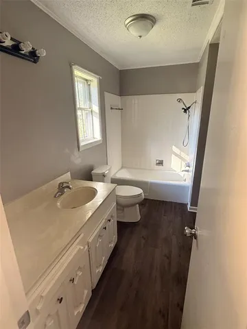 a bathroom with a granite countertop sink mirror vanity and toilet