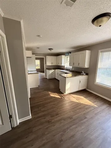 a kitchen with granite countertop a refrigerator stove and wooden floor