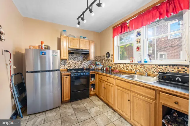 a kitchen with stainless steel appliances a refrigerator sink and cabinets