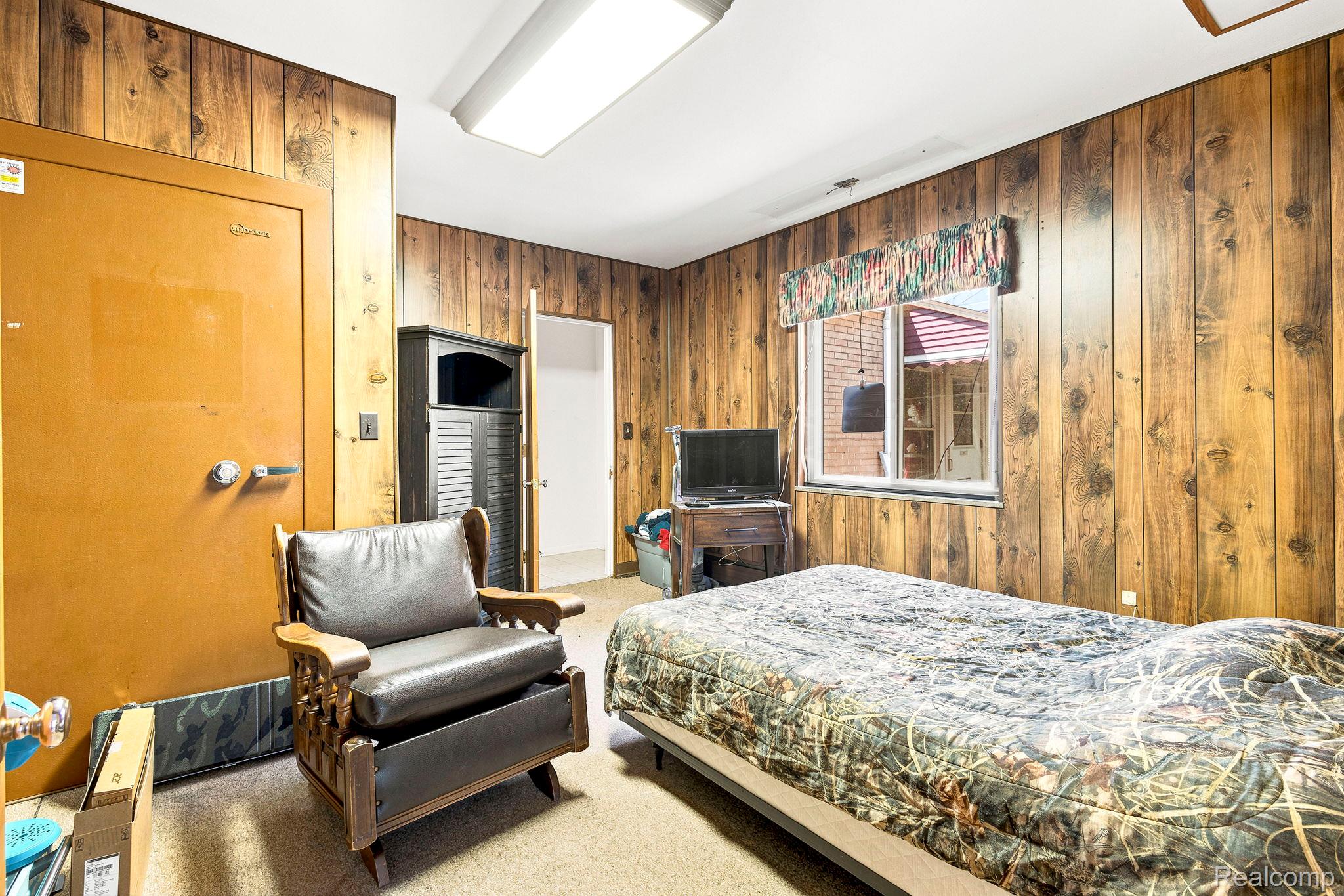 9735 Dolan Road Columbus, MI 48063 - Photo 28 of 63 Room featuring wood-paneled walls, a rectangular window, and a built-in metal safe
