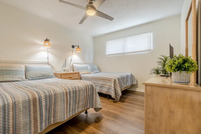 a bedroom with two beds and potted plant