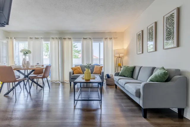 a living room with furniture and wooden floor