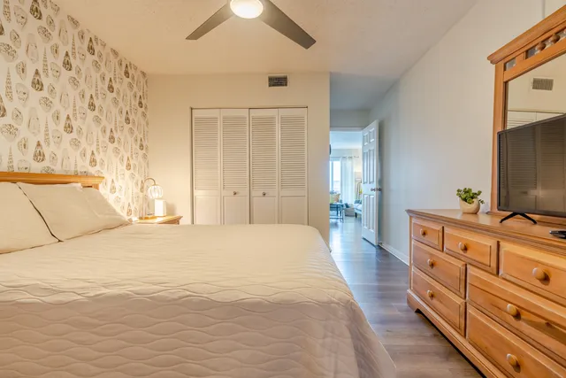 a spacious bedroom with a bed and a flat screen tv