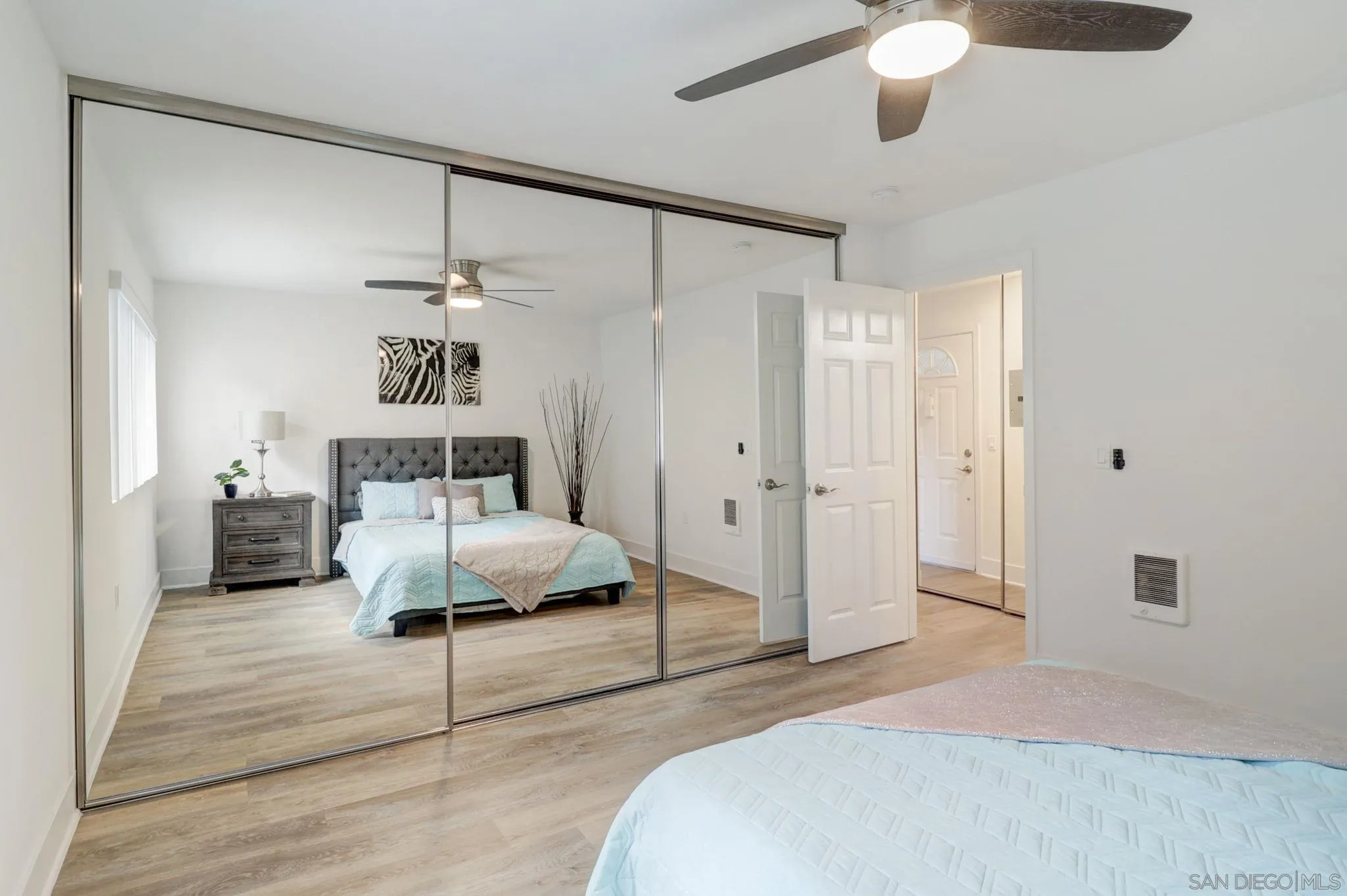 8660 Via Mallorca, Unit B La Jolla, CA 92037 - Photo 13 of 27 a spacious bedroom with a bed and a chandelier