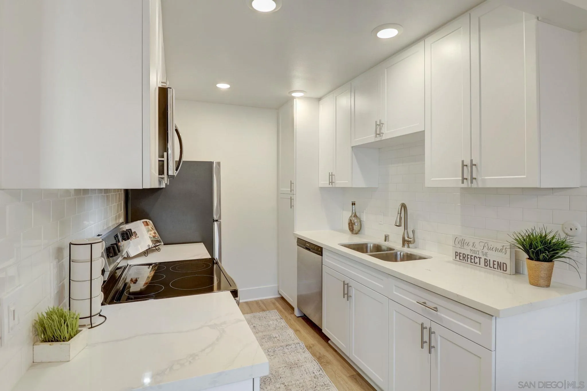 8660 Via Mallorca, Unit B La Jolla, CA 92037 - Photo 9 of 27 a kitchen with stainless steel appliances kitchen island granite countertop a sink a stove and a refrigerator