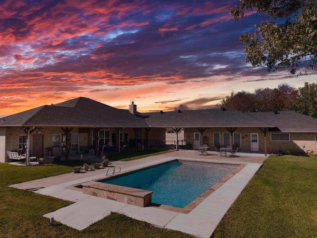 a view of a patio with swimming pool and a chairs