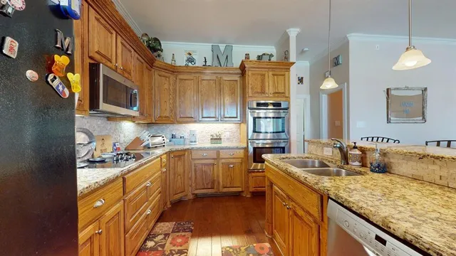 a kitchen with stainless steel appliances granite countertop a sink stove and refrigerator