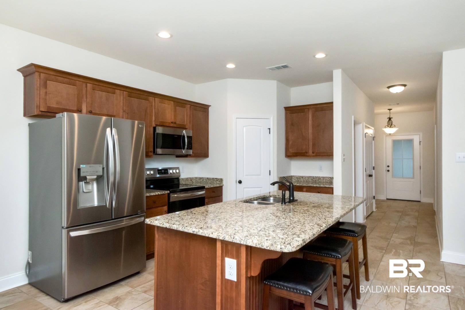 10714 Brodick Loop Spanish Fort, AL 36527 - Photo 7 of 26 Kitchen featuring stainless steel appliances, light stone counters, a breakfast bar area, a center island with sink, and recessed lighting