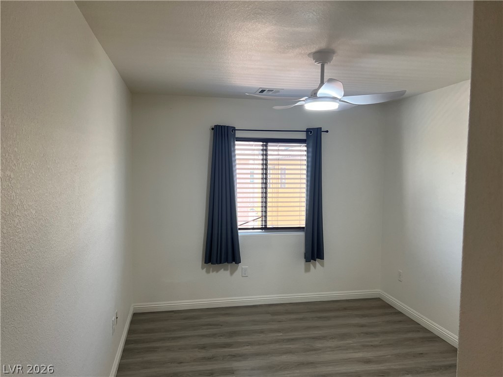 9581 Aberdeen Ridge Court Las Vegas, NV 89148 - Photo 21 of 25 A well-lit room featuring durable wood flooring and a modern ceiling fan for comfort.