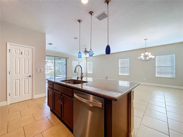 a kitchen with a sink a counter space and a chandelier