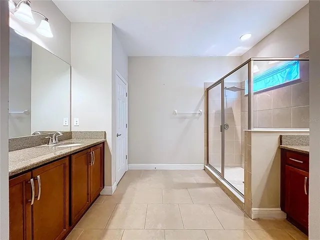 a bathroom with a granite countertop sink a mirror and a bathtub