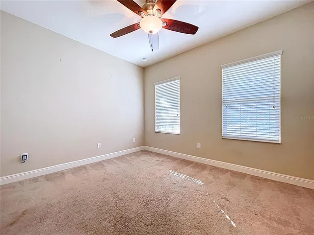 an empty room with closet and a chandelier fan
