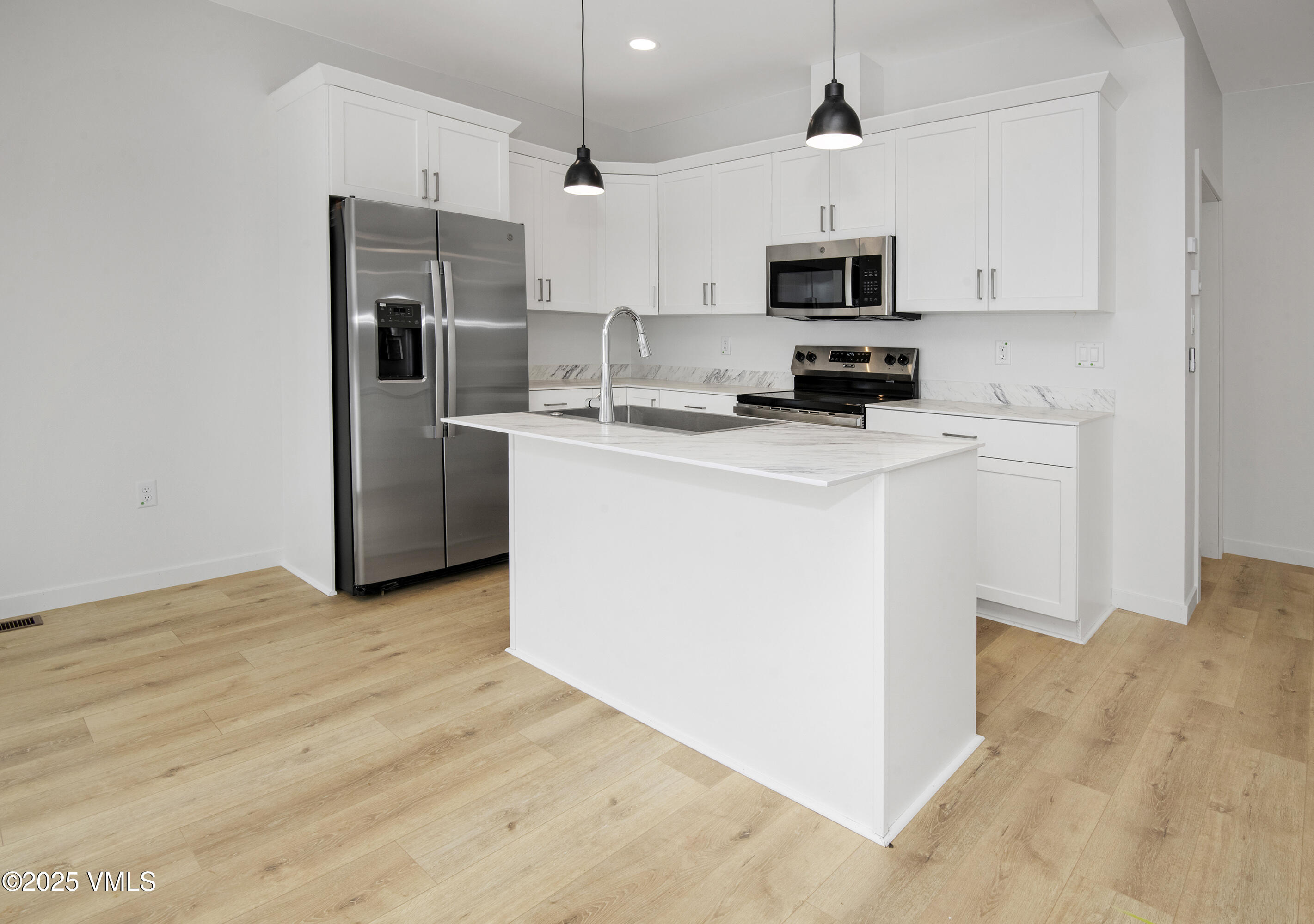 90 Comanche Way Gypsum, CO 81637 - Photo 8 of 46 a kitchen with stainless steel appliances a stove a microwave a sink a refrigerator and white cabinets