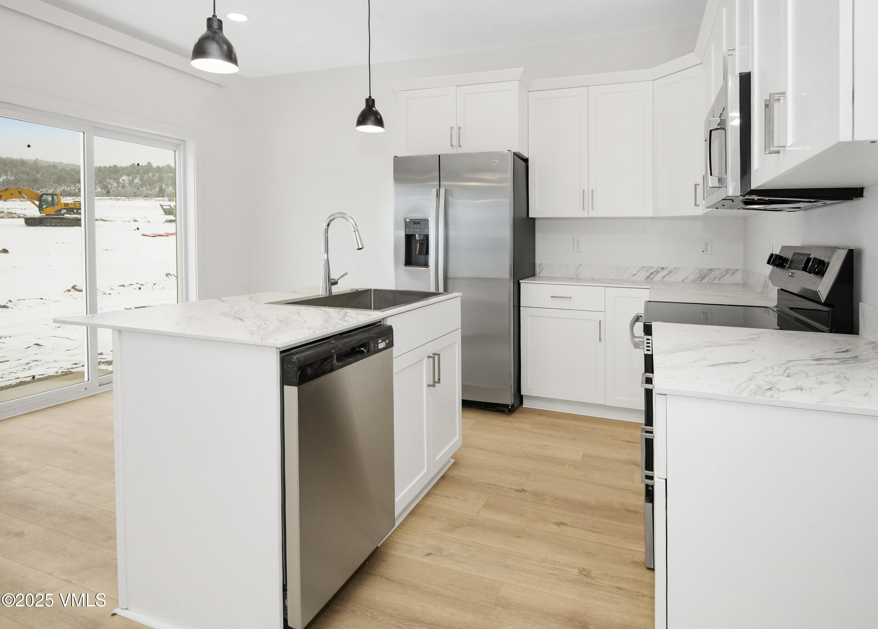 90 Comanche Way Gypsum, CO 81637 - Photo 9 of 46 a kitchen with a sink a refrigerator and cabinets
