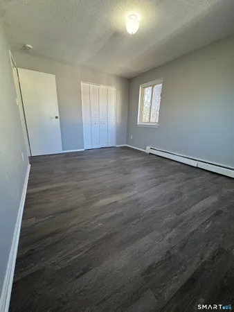 an empty room with wooden floor and window