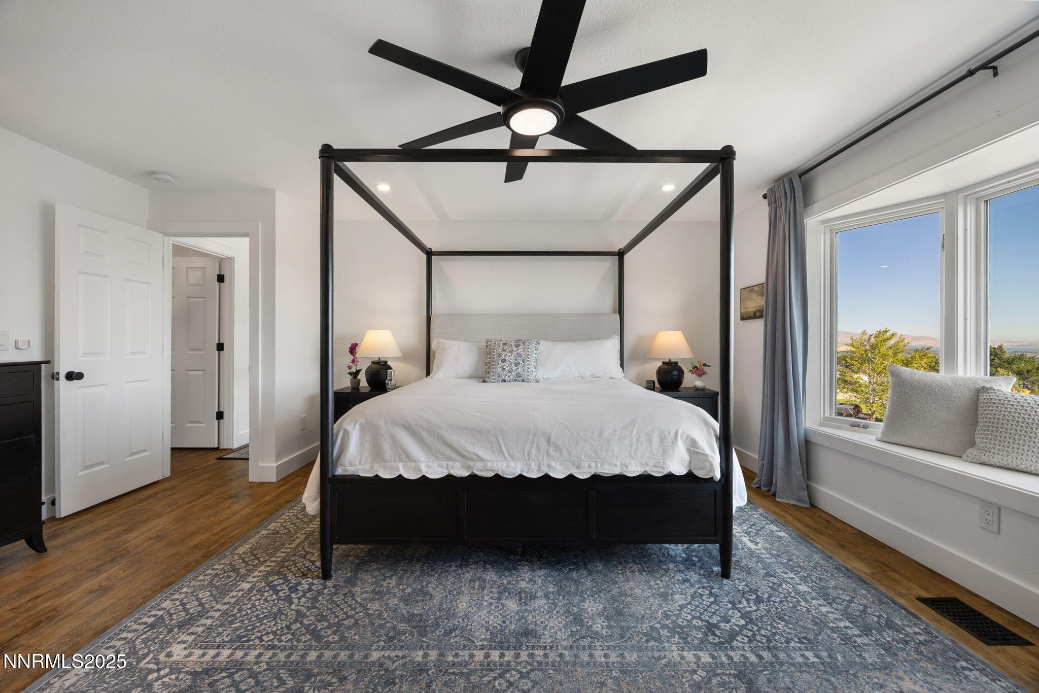 13205 Welcome Way Reno, NV 89511 - Photo 18 of 79 a bed sitting in a bedroom next to a window with a chandelier