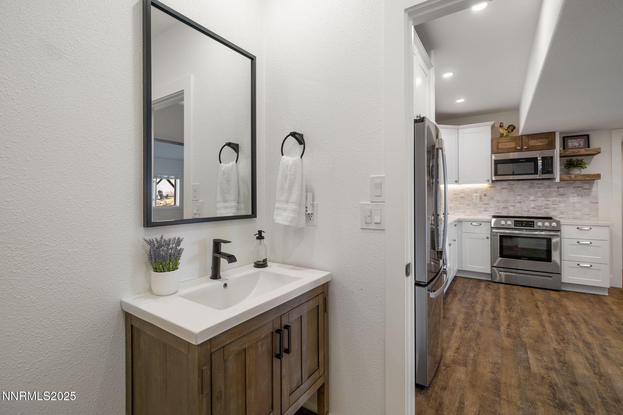 13205 Welcome Way Reno, NV 89511 - Photo 53 of 79 a bathroom with a sink a large mirror and a refrigerator