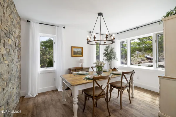 a kitchen with stainless steel appliances granite countertop a table chairs and a refrigerator