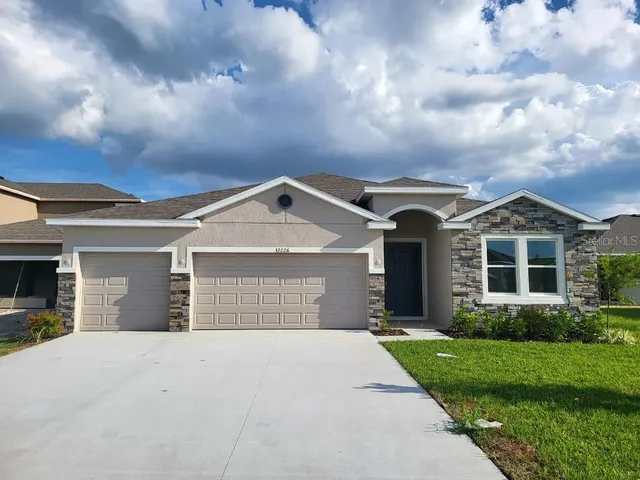 a front view of a house with a yard and garage
