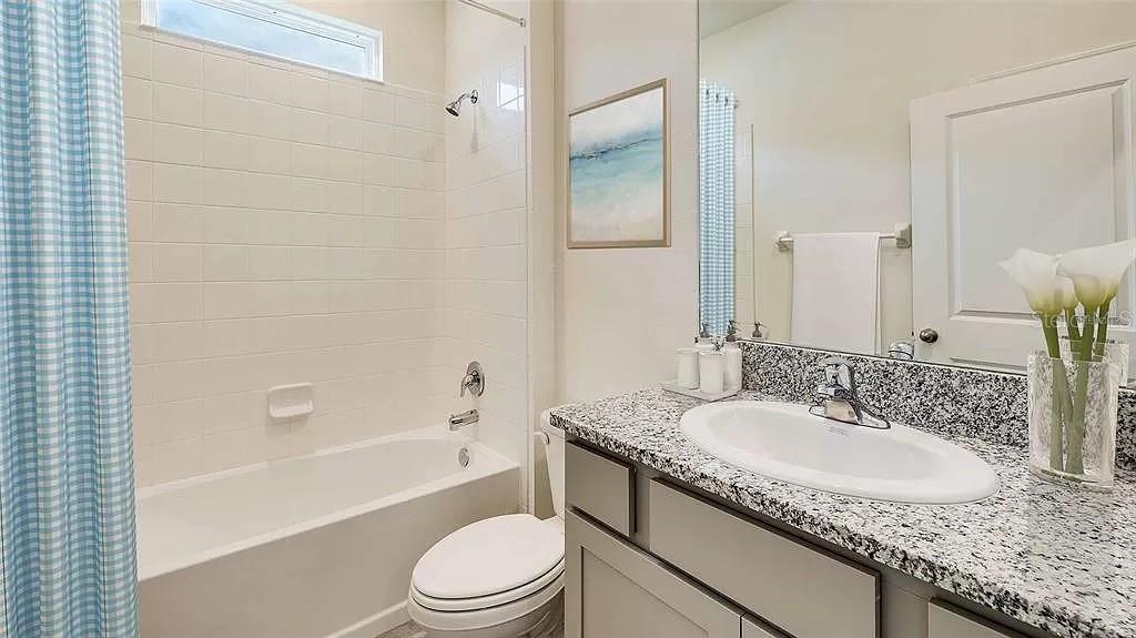 32226 Eldorado Cyn Loop Wesley Chapel, FL 33543 - Photo 16 of 18 a bathroom with a granite countertop toilet a sink and bathtub