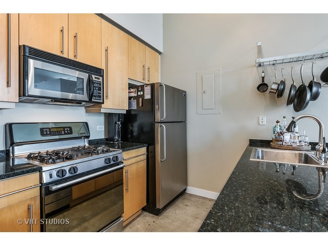 939 West Madison Street, Unit 604 Chicago, IL 60607 - Photo 6 of 10 a kitchen with stainless steel appliances kitchen island a stove and a sink