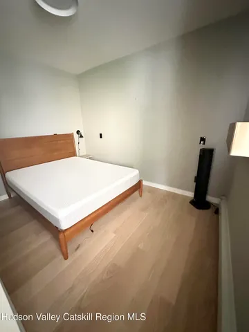 a white bed sitting in a bedroom next to a larger window