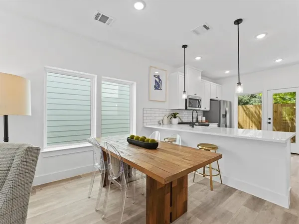 a kitchen with a table chairs stove and cabinets