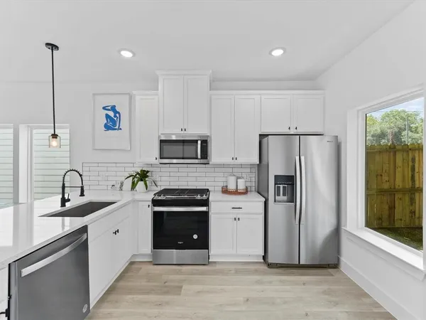 a kitchen with a sink appliances and cabinets