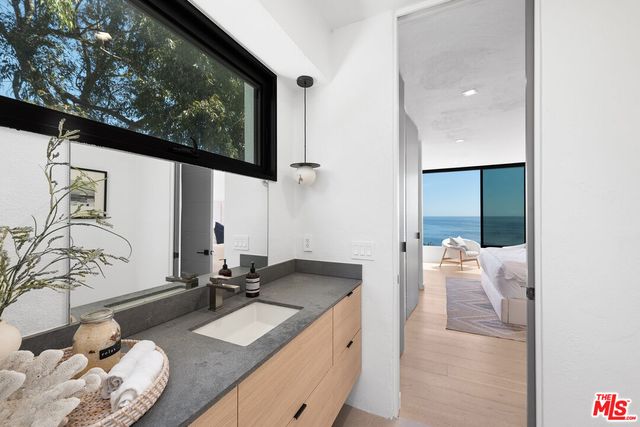 a bathroom with a granite countertop sink and a mirror