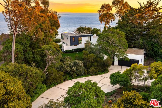 a view of a house with a yard and potted plants