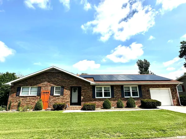 a front view of a house with a yard and trees