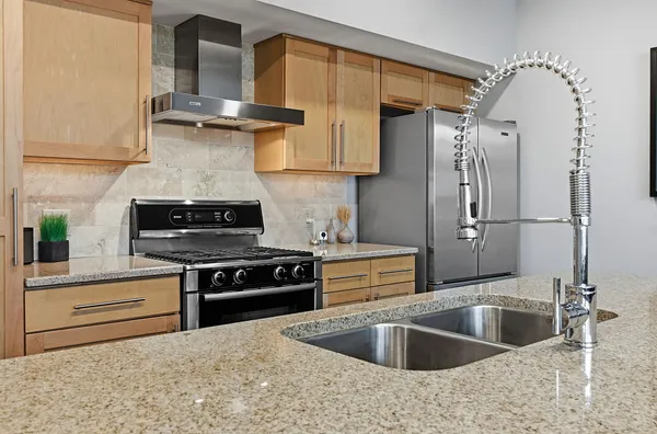 a kitchen with stainless steel appliances granite countertop a sink stove and refrigerator