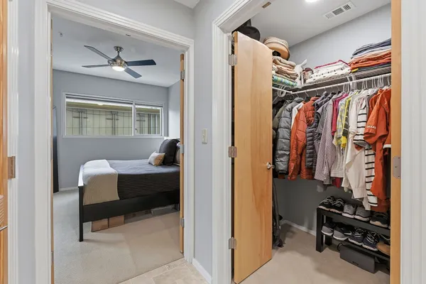 a view of walk in closet with clothes and shoes