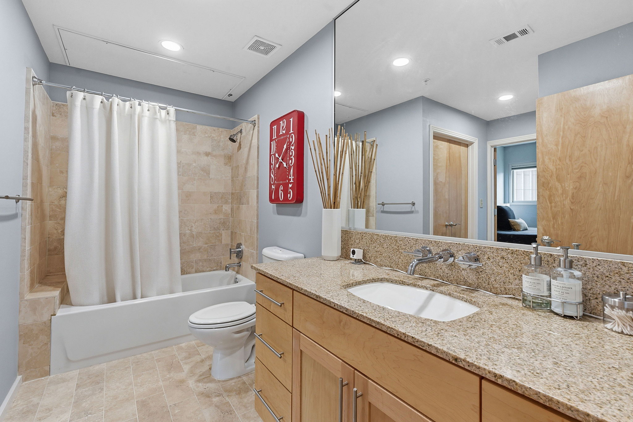 1600 Barton Springs Road, Unit 1106 Austin, TX 78704 - Photo 19 of 39 a bathroom with a granite countertop sink a toilet a mirror a vanity and shower