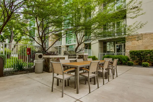 a view of a patio with table and chairs potted plants and large tree