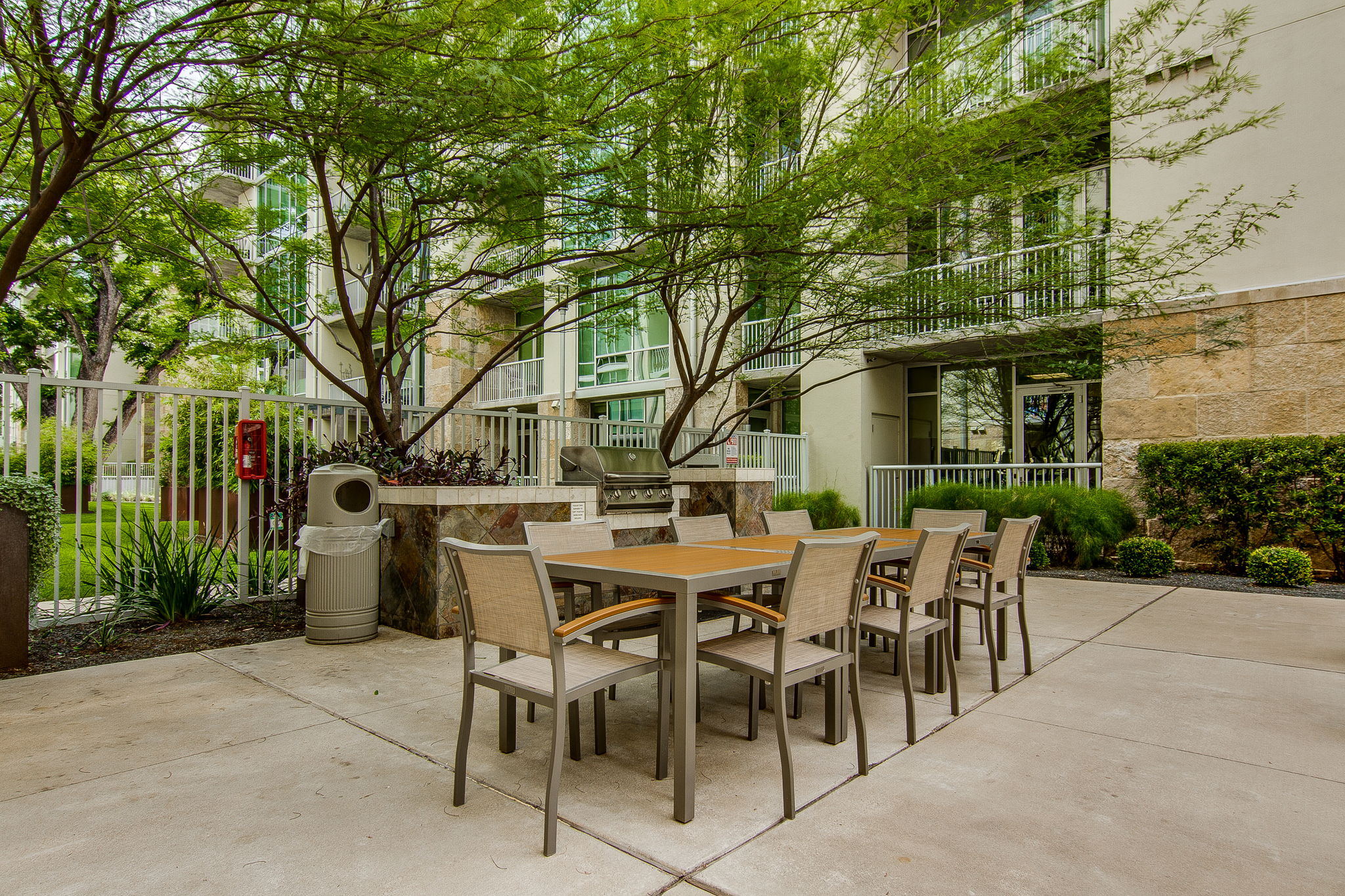 1600 Barton Springs Road, Unit 1106 Austin, TX 78704 - Photo 35 of 39 a view of a patio with table and chairs potted plants and large tree